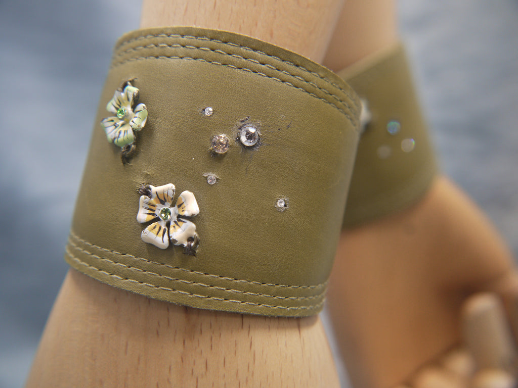 Moss Green Leather cuff with enamel flowers and enbedded crystals in pastl shades. Tripple stitch detail  