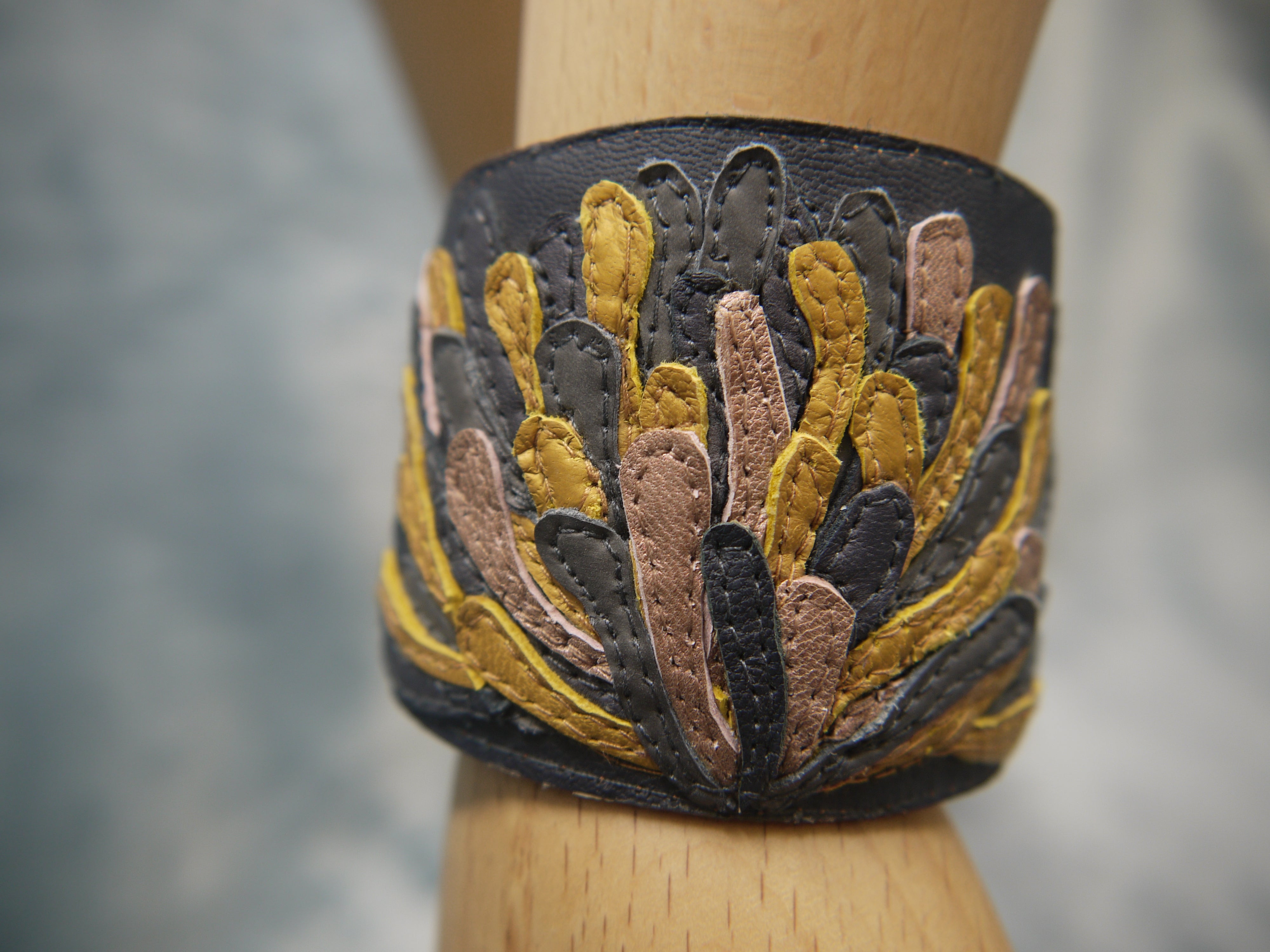 Chysanthemum Leather Cuff in anthracite grey with hand cut petals in sunshine yellow, pale bronze and grey , one-of-a- kind, unique, made in Italy by designer-makers