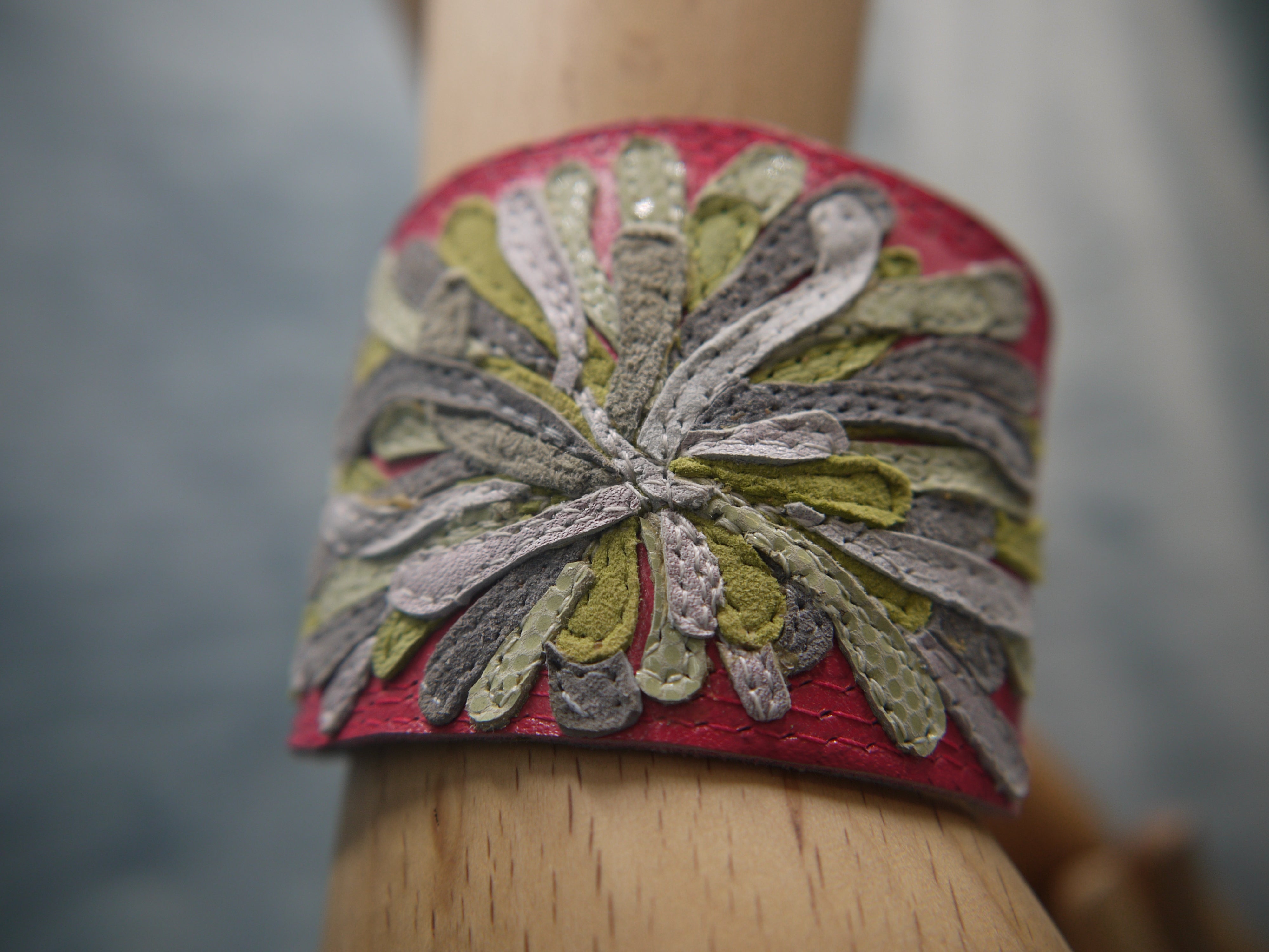 Chysanthemum Leather Cuff in hot pink with hand cut petals in pale grey, white, green petals , one-of-a- kind, unique, made in Italy by designer-makers.Close-up of stitchwork