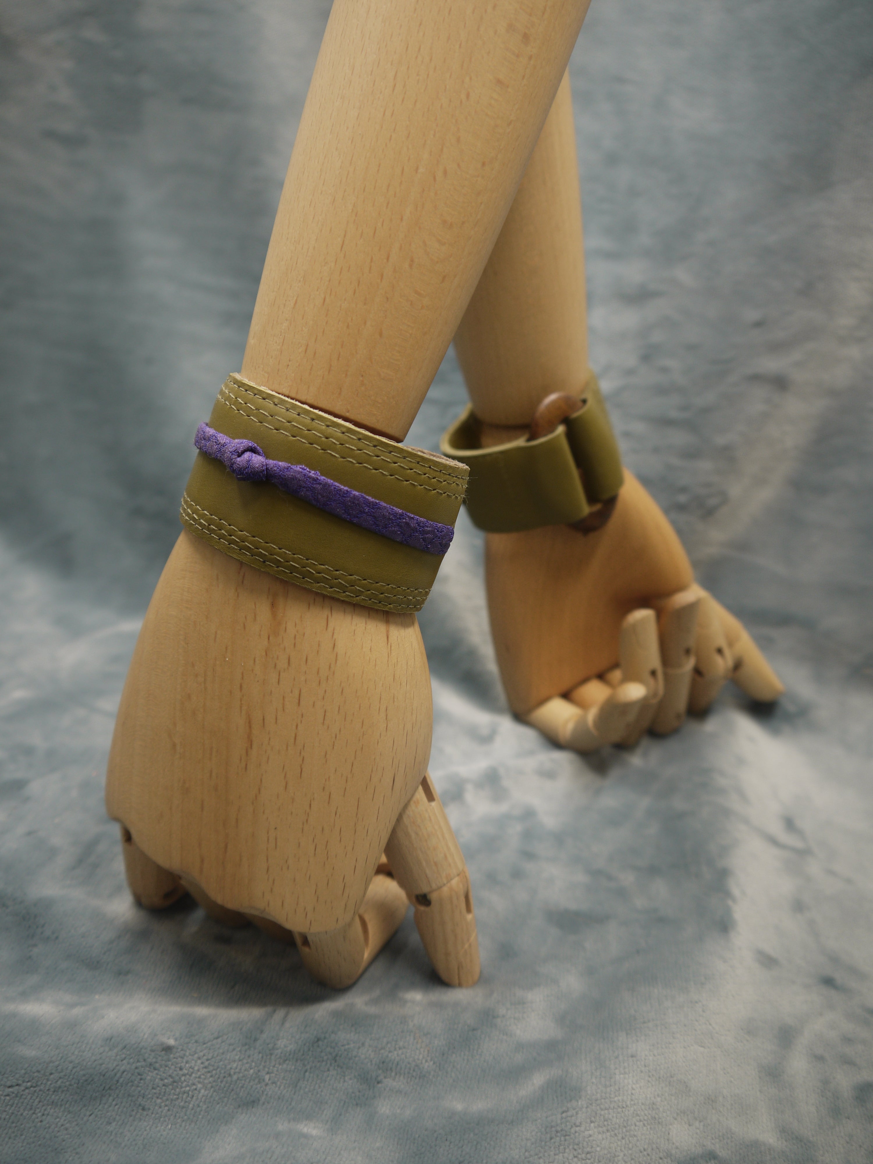 Olive green slimline Italian leather cuff with royal purple slim silk knot central on the cuff. The cugff has elegant repeat stitch detail around the edges. Close-Up Image