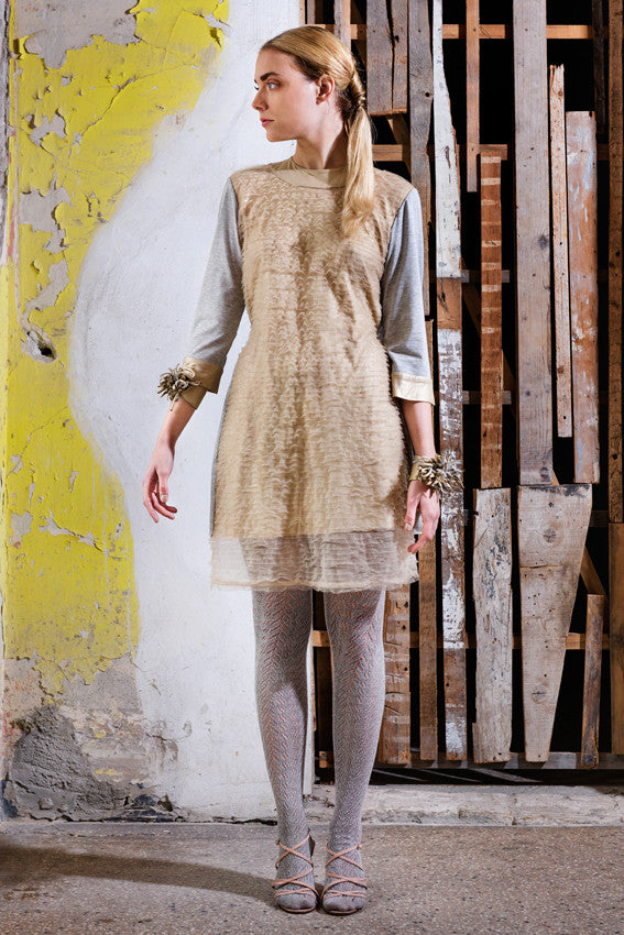 Model wears Dandelion Draped T-Shirt Dress. The cotton jersey knee length dress is casual yet elegant. Easy to wear, yet spetacular. Work with smokey dandelion cuffs in leather and jersey