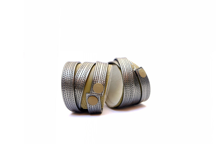 Moss green Italian leather cuff with leather gunmetal strip that wraps around the wrist as a contrast section with repeat stitch detail. Two cuffs are shown 